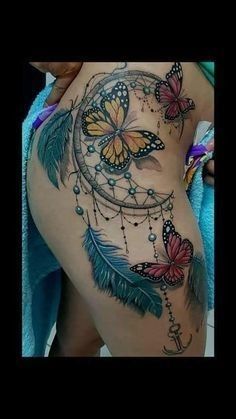 a woman's stomach with butterflies and a dream catcher tattoo on it