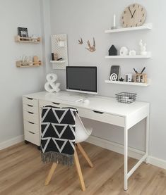 a white desk with a computer on top of it and shelves above the desk behind it