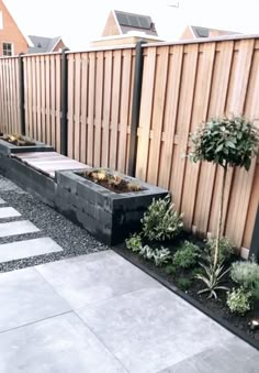 an outdoor garden with wooden fence and planters