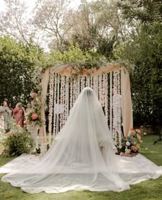 a bride's veil is draped over her wedding dress as she walks down the aisle