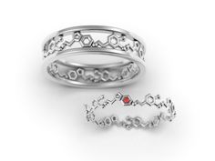 two silver rings with red stones on them