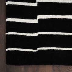 black and white striped rug on wooden floor