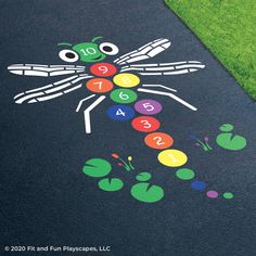 a child's play area with an insect painted on the ground and numbers written in different colors