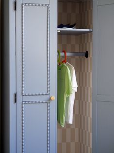 an open closet with clothes hanging on hooks