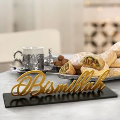 some pastries are sitting on a plate with the word bismilla spelled in gold