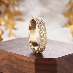 a gold wedding ring sitting on top of a wooden table