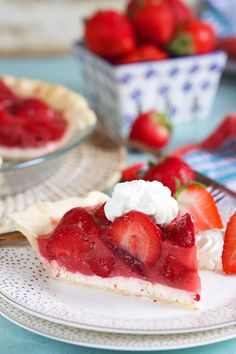 a slice of strawberry pie on a plate with strawberries in the background