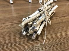 several pieces of wood tied together on a wooden table with white pegs and twine