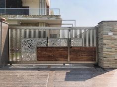 an iron gate with wood and glass panels in front of a building