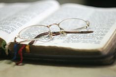 a pair of reading glasses resting on an open book