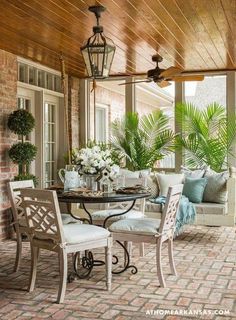 a patio with lots of furniture and potted plants