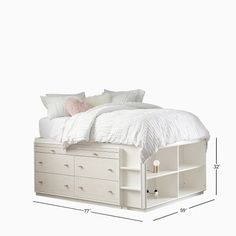 a white bed with drawers underneath it and a pillow on the headboard next to it