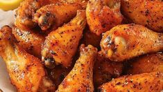 chicken wings with lemon wedges on the side