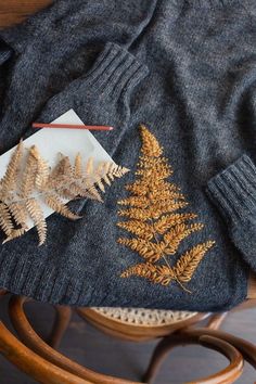 a sweater and some leaves on a table