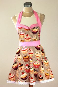 a dress with cupcakes on it and pink ribbon around the neck is displayed on a mannequin