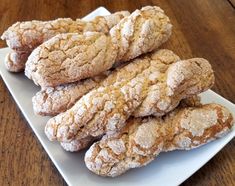 a white plate topped with cookies covered in powdered sugar