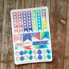 a sticker sheet with hearts and arrows on it next to a piece of wood