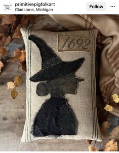 an embroidered pillow with a witch's hat on it