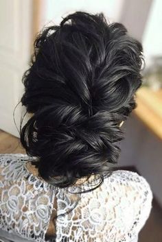 the back of a woman's head with black hair in a low bun braid