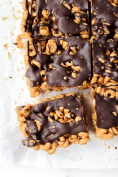 chocolate covered cookies with walnuts on top are arranged in squares and rectangles