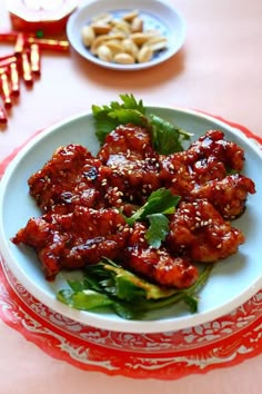 a white plate topped with meat and greens on top of a red and white table