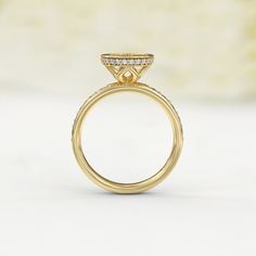 a yellow gold engagement ring with diamonds on the top and side stones in the middle