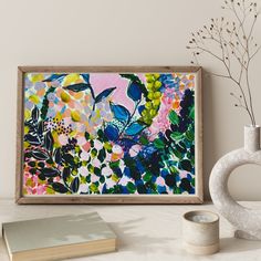 a painting on the wall next to a vase with flowers