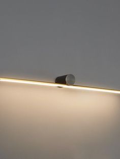 a light that is on the side of a wall in a room with white walls