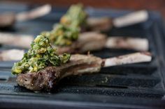 some meat with broccoli on top of it sitting on a grilling pan