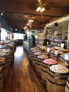 a store filled with lots of wooden barrels full of different types of candy and candies