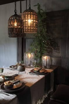 a dining room table set with plates and candles