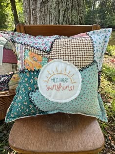 a wooden chair sitting in front of a tree with some pillows on top of it