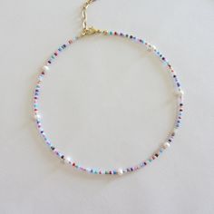 Colorful beaded choker necklace, Freshwater pearl necklace, 18k gold necklace, Rainbow seed bead necklace for women I offer two versions of an iridescent necklace with freshwater pearls, with gold beads, with a clasp and chain extension made of brass with 18k gold plating. Second version of the necklace with silver beads and stainless steel clasp. Measure the length of your neck with a measuring tape or you can use any string, rope or phone cable, and afterward apply the measurements on a regula Pearl Choker With Colorful Round Beads, Pearl Choker With Colorful Beads For Gifts, Pearl Chain Choker With Round Beads, Colorful Pearl Beaded Choker Necklace, Pearl Choker With Tiny Beads, Pearl Choker Necklace With Tiny Beads, Dainty Pearl Beaded Necklaces With Tiny Beads, Dainty Pearl Necklace With Colorful Beads, Pearl Choker Necklace With Colorful Beads