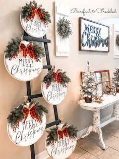 christmas decorations are hanging on the wall next to a white table with a red bow