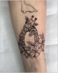 a giraffe with flowers around it's neck is shown on the leg