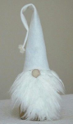 a white hat with feathers on it sitting on top of a bed next to a wall