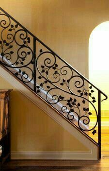 a stair case with wrought iron railing and wood flooring