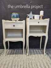 two white nightstands sitting next to each other on top of a carpeted floor