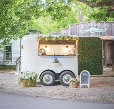 an ice cream truck parked in front of a building with plants growing out of it