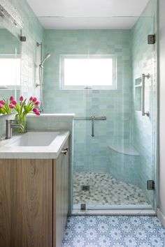 a bathroom with a sink, toilet and shower stall in the corner next to a window