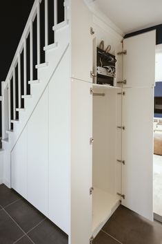 an open cabinet under the stairs in a house