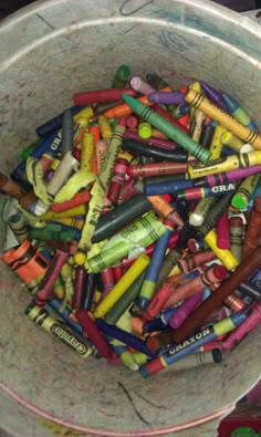 a bucket full of crayons sitting on top of a table