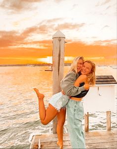 two women hugging each other on a dock