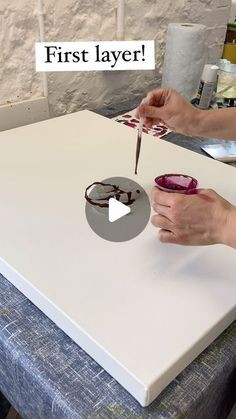 a person cutting up some food with a knife on top of a white board that says first layer