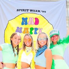 three women are posing for a photo in front of a sign that says mad hippy