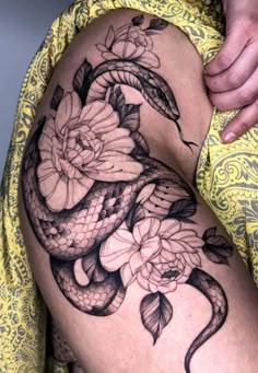 a woman's thigh with a snake and flowers on it