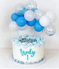 a birthday cake with blue and white balloons