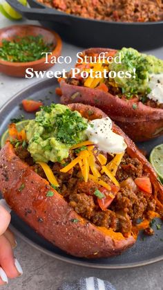 taco stuffed sweet potatoes on a plate with guacamole