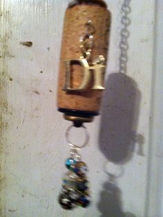 a cork and glass bead necklace hanging from a door