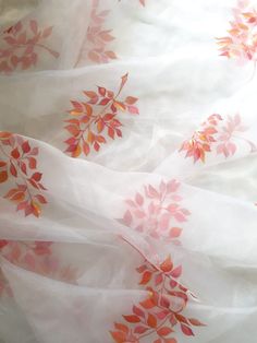 the fabric is white with red leaves on it